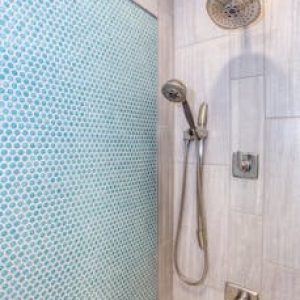 Elegant shower design featuring blue mosaic tiles and stainless steel fixtures.